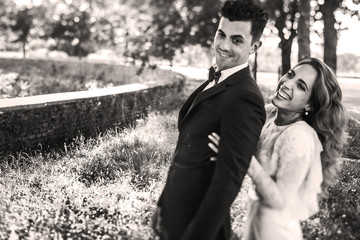 Black and white picture of smiling bride cathing groom from behi