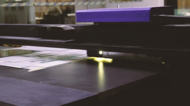 Maszyna drukująca pracuje na hali przemysłowej w hali produkcyjnej, widok na głowicę drukarki UV