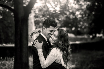Black and white picture of gorgeous wedding couple hugging on th