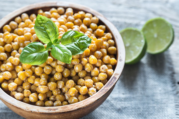 Bowl of roasted chickpeas on the wooden background