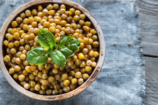 Bowl of roasted chickpeas on the wooden background