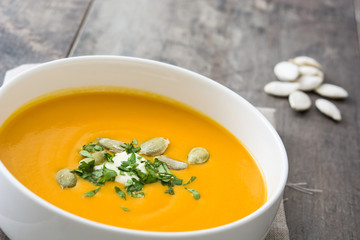 Pumpkin soup in bowl and pumpkin seeds

