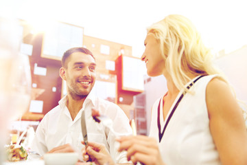 happy couple eating dinner at restaurant terrace