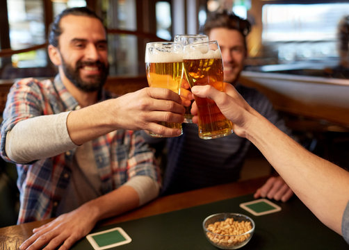 happy male friends drinking beer at bar or pub