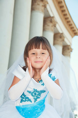 Little bride. A girl in a lush white and blue wedding dress and