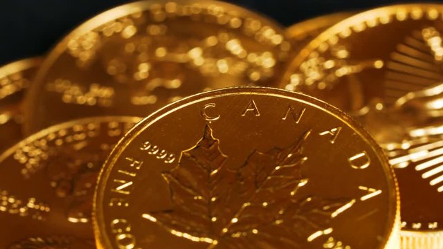 4K macro video with close up of the word Canada on a rotating gold Canadian Maple Leaf golden coin representing safe investment or return to gold standard