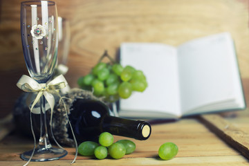 wooden table with wine bottle book and grape