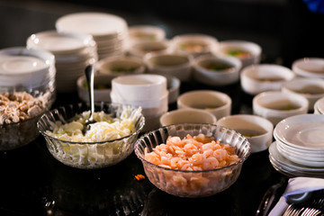 Bowls with snacks stand before the plates with sauces