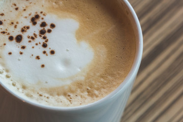 a cup of hot latte,coffee art  on the wooden table in relex time