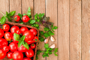 Red tomatoes in a wicker basket on a wooden table