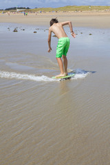 Jeune garçon avec sa planche en bord de mer