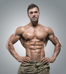 Fototapeta na wymiar Muscular athlete bodybuilder man on a gray background