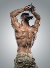 Fototapeta na wymiar Muscular athlete bodybuilder man on a gray background