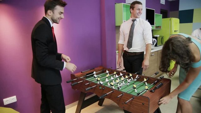 Office workers playing table football