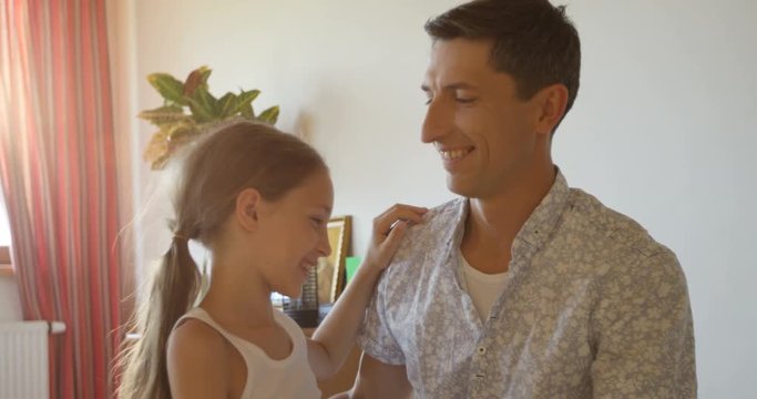 Charming portrait of happy father and daughter embracing at home interior background