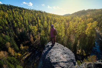 girl stands high on a cliff
