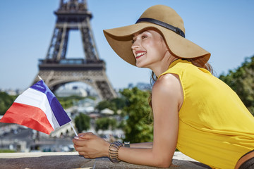 Fototapeta premium happy woman with French flag in front of Eiffel tower in Paris