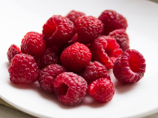 Fresh raspberries on a white saucer