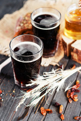 
summer and autumn cooling drink , kvass or  dark beer with honey , raisins and rye bread on a wooden background