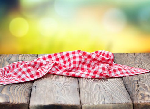 Red Picnic Cloth On Wooden Table Mature Bokeh Background.