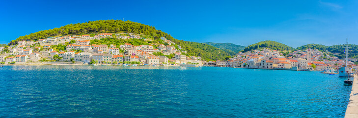 Obraz premium Pucisca town summer panorama. / Waterfront summer panorama at town Pucisca, picturesque place on Adriatic sea, Island of Brac, Croatia.
