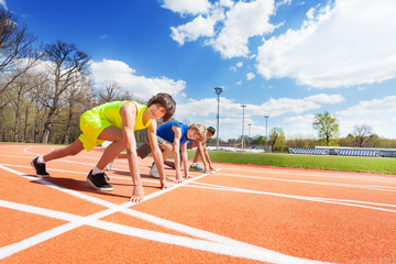 Three teenage athletes lined up ready to race