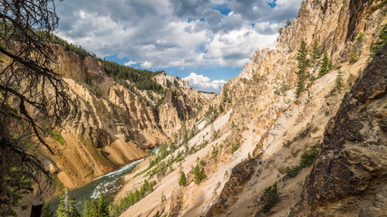Stormy river flows in a narrow gorge in the rocks. Uncle Toms Trail on The Grand Canyon of the Yellowstone National Park, Wyoming