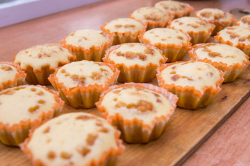 Freshly baked muffins lie on a wooden tray