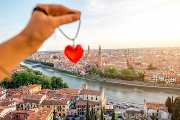 Holding decoration in the form of heart on the italian town Verona background. Verona is famous...