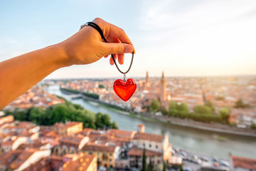 Holding decoration in the form of heart on the italian town Verona background. Verona is famous...
