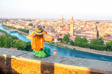 Woman enjoying beautiful view on Verona city in Italy on the sunrise. Verona is famous city of love...