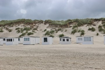Beach with sand dunes and small bath houses in Lokken, North Jutland, Denmark, Europe.