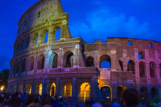 Roman Colosseum illuminated with different colors at twilight