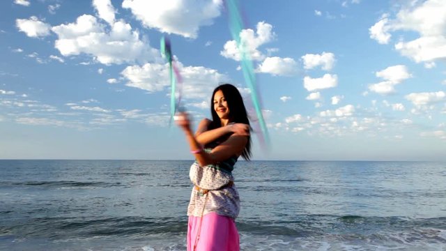 women playing with poi at the beach