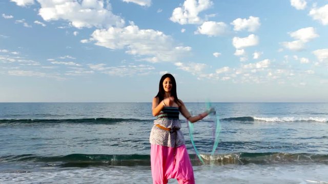 women playing with poi at the beach