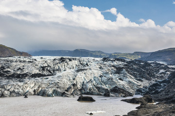 Jokulsarlon glacier covered with black volcanic ash. Vatnajokull National Park. Iceland.
