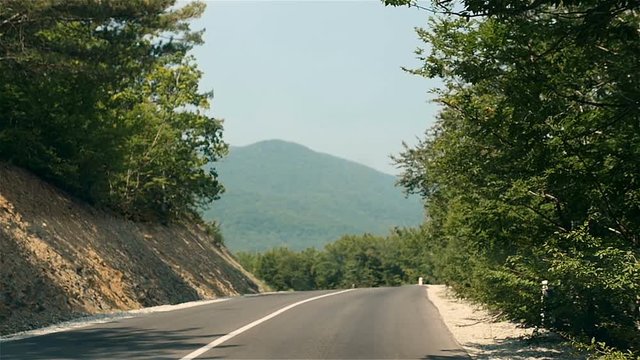 Driving On Mountain Road Through Forest With Turns. Driving On An Empty Road On a Bright Summer Day In Mountains
