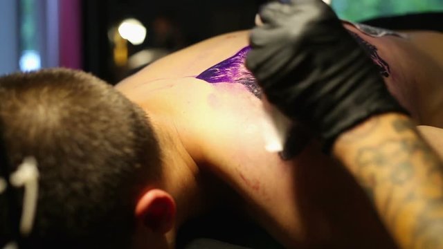Artist makes a tattoo Wolf
