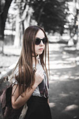 Beautiful girl in sunglasses and with a bag.