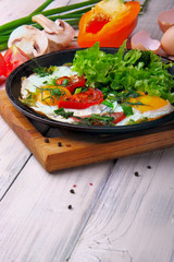 Fried eggs (scrambled) on the frying pan wit sweet pepper and di