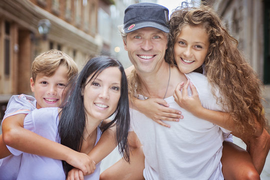 Summer Family Portrait Of Parents And Kids Outside In Urban Style