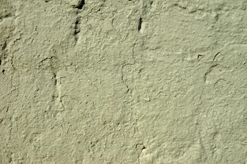 The old plastered wall cracked of yellow green paint.