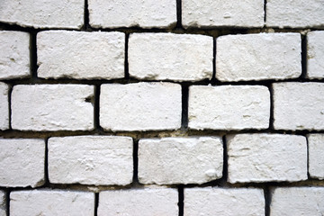 Old wall of bricks painted with white paint, close-up.