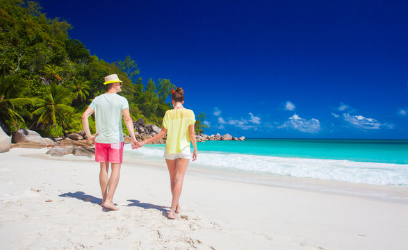 attractive couple enjoying sunny day at Anse Georgette beach. Praslin, Seychelles