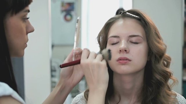 Makeup artist making make-up for the stylish bride