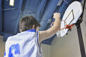 A teenager basketball player play his favorite sport