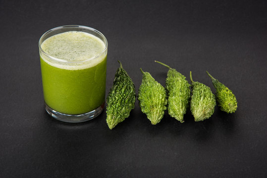 Herbal Juice Of Green Momodica In A Glass With Sliced Vegetables, Karela Juice Or Bitter Gourd Juice