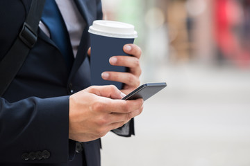 Businessperson Hand With Mobile Phone And Coffee Cup