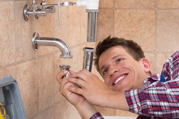 Plumber Fitting Sink Pipe In Bathroom