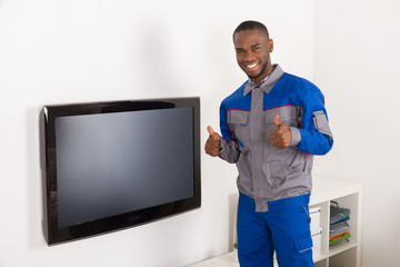 Technician Near The Television Showing Thumb Up